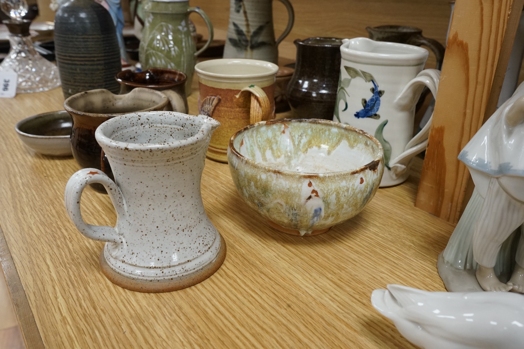 A large collection of studio pottery mugs bowls and jugs, tallest jug 21cm.